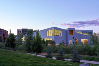 Faraway shot of NoBo Library amongst trees and greenery.